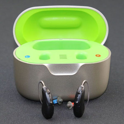 Charging case with neon green inside and hearing aids sitting in front of the case