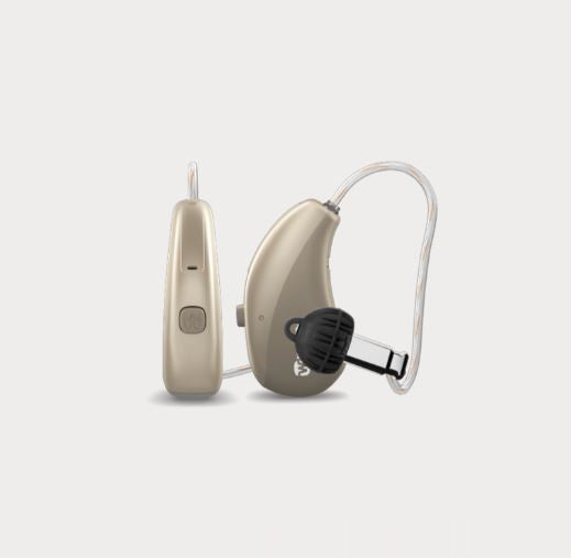 Pair of golden brown hearing aids on a light gray background