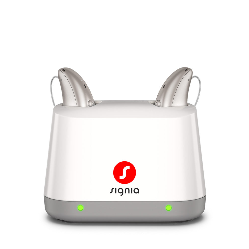 Signia Desktop Charger 2.0 holding a pair of Pure Charge&Go MaX hearing aids while they charge.