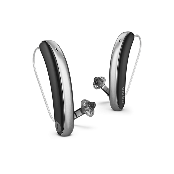 Pair of silver and black hearing aids a white background