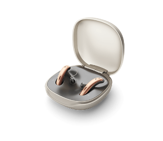 Pair of hearing aids in an open beige case on a white background
