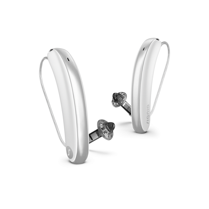 Pair of silver hearing aids on a white background